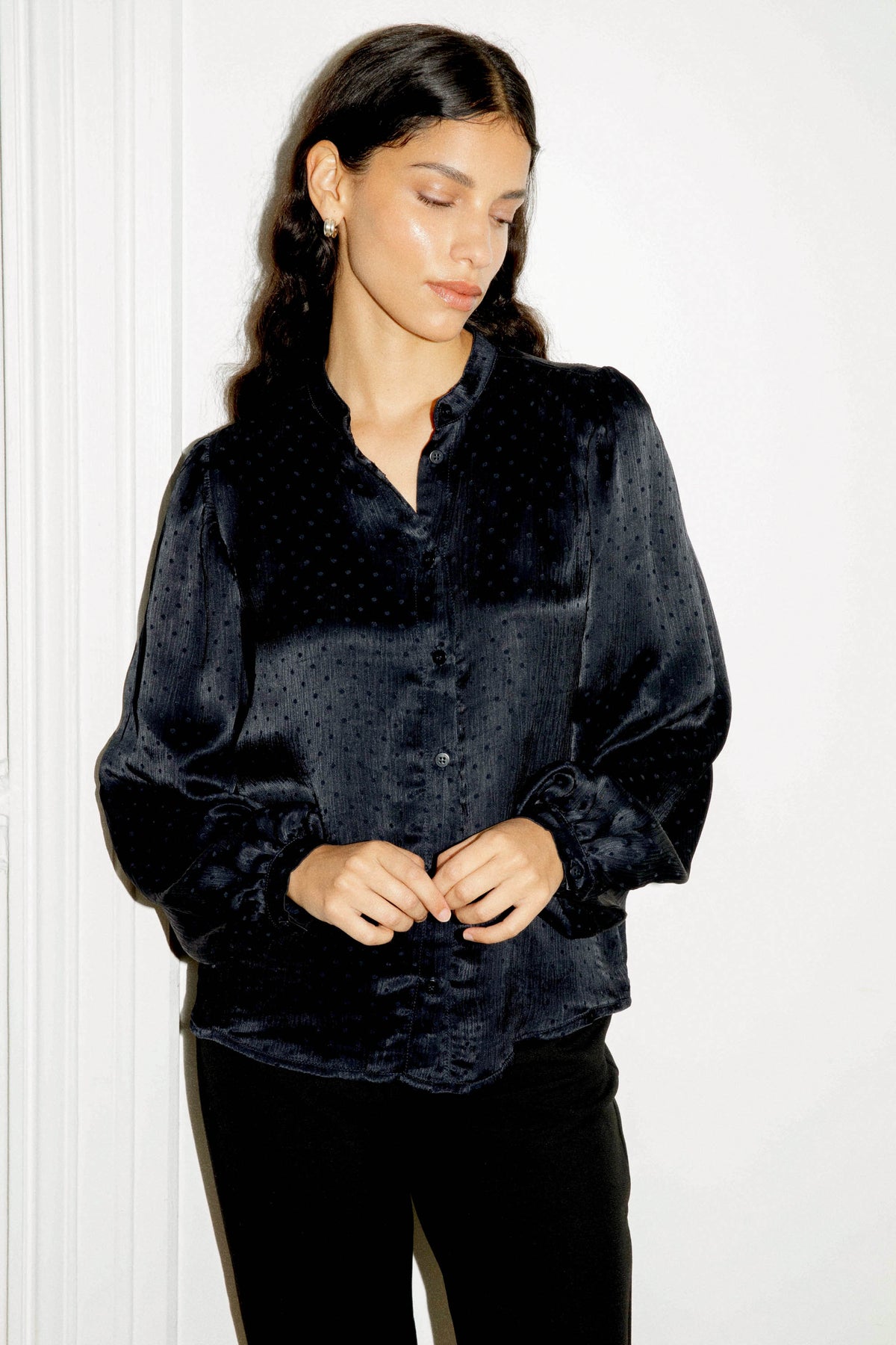 Blouse bleu marine à pois en viscose, portée avec un pantalon noir, une silhouette féminine et élégante signée Avani Apparel.