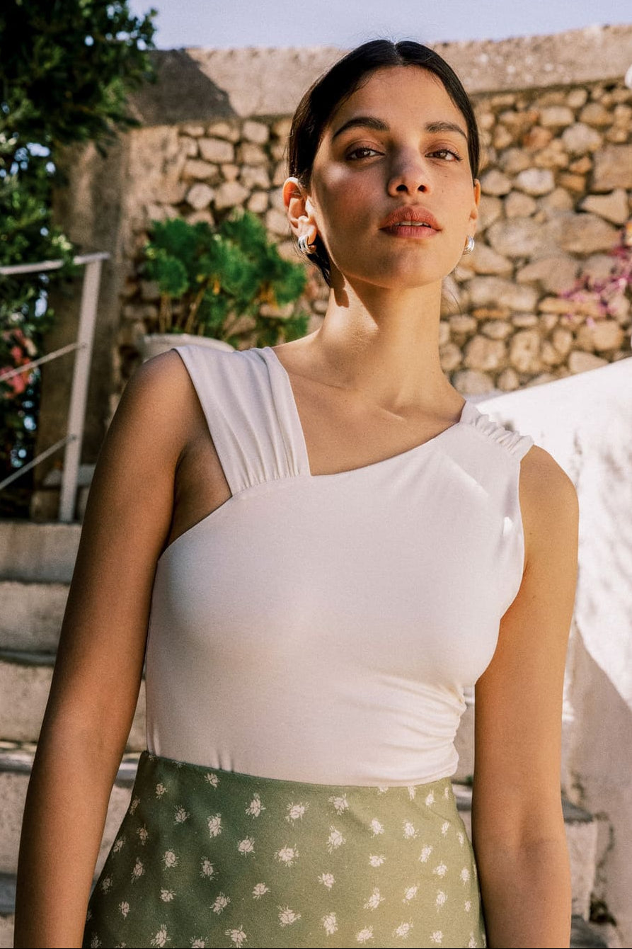 Body écru en jersey Tencel avec encolure asymétrique et bretelles drapées, fabriqué au Portugal