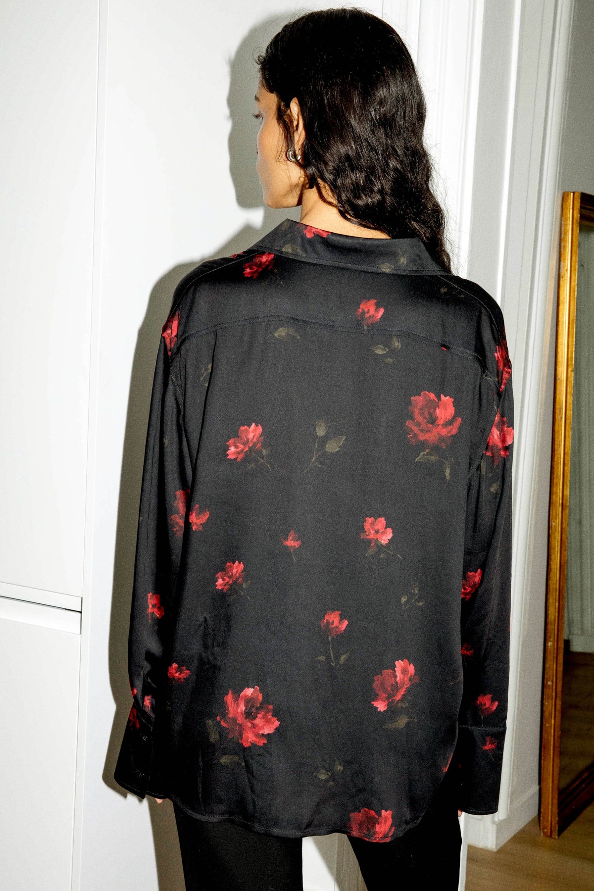 Vue de dos d'une chemise noire à fleurs pour femme, en satin de viscose ECOVERO™, à manches longues et coupe fluide, confectionnée au Portugal.