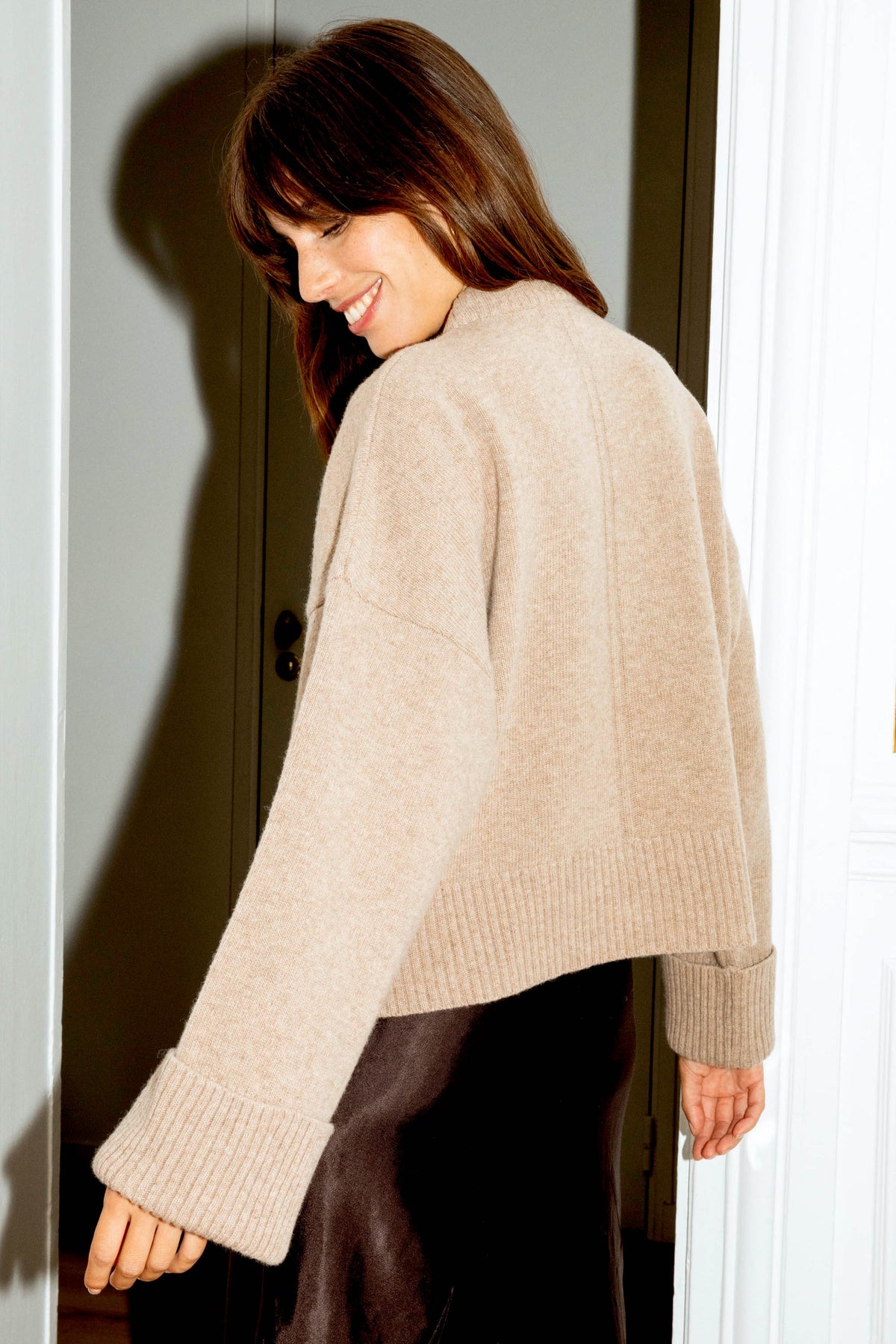 Vue de dos d'un pull beige en laine mérinos pour femme, à la coupe ample et aux manches évasées, confectionné au Portugal.