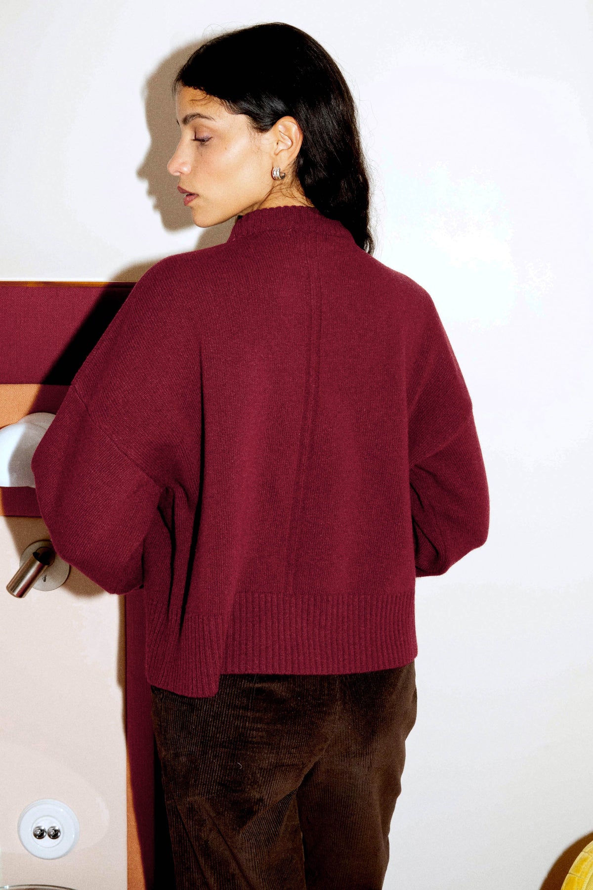 Vue de dos d'un pull bordeaux en laine mérinos pour femme, à la coupe ample et aux manches évasées, confectionné au Portugal.