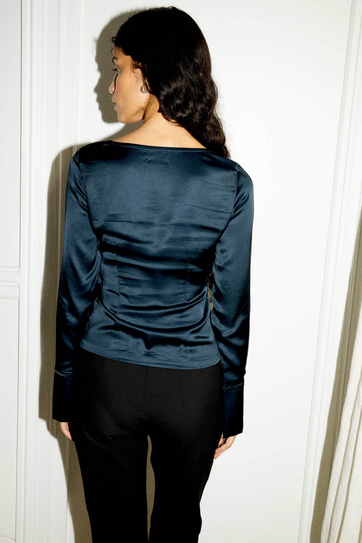 Vue de dos d'un top bleu marine en satin de viscose ECOVERO™ pour femme, à manches longues et coupe ajustée, confectionné au Portugal.